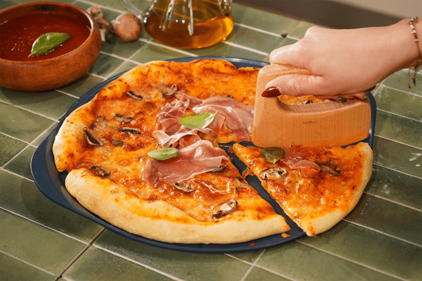 Cookut Le Formidable pizzalautanen mustikkapizzaleikkurilla varustettuna